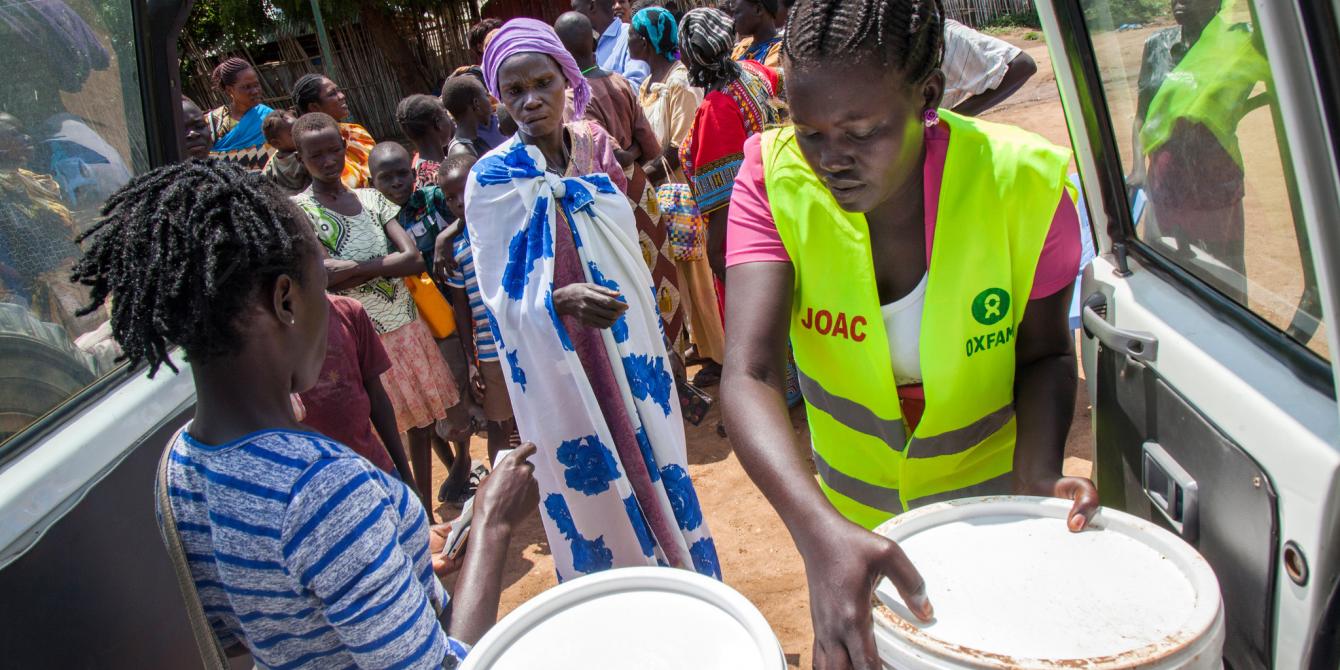 Oxfam staff distributing water treatment kits in Juba, South Sudan. Albert Gonzalez Farran / Oxfam