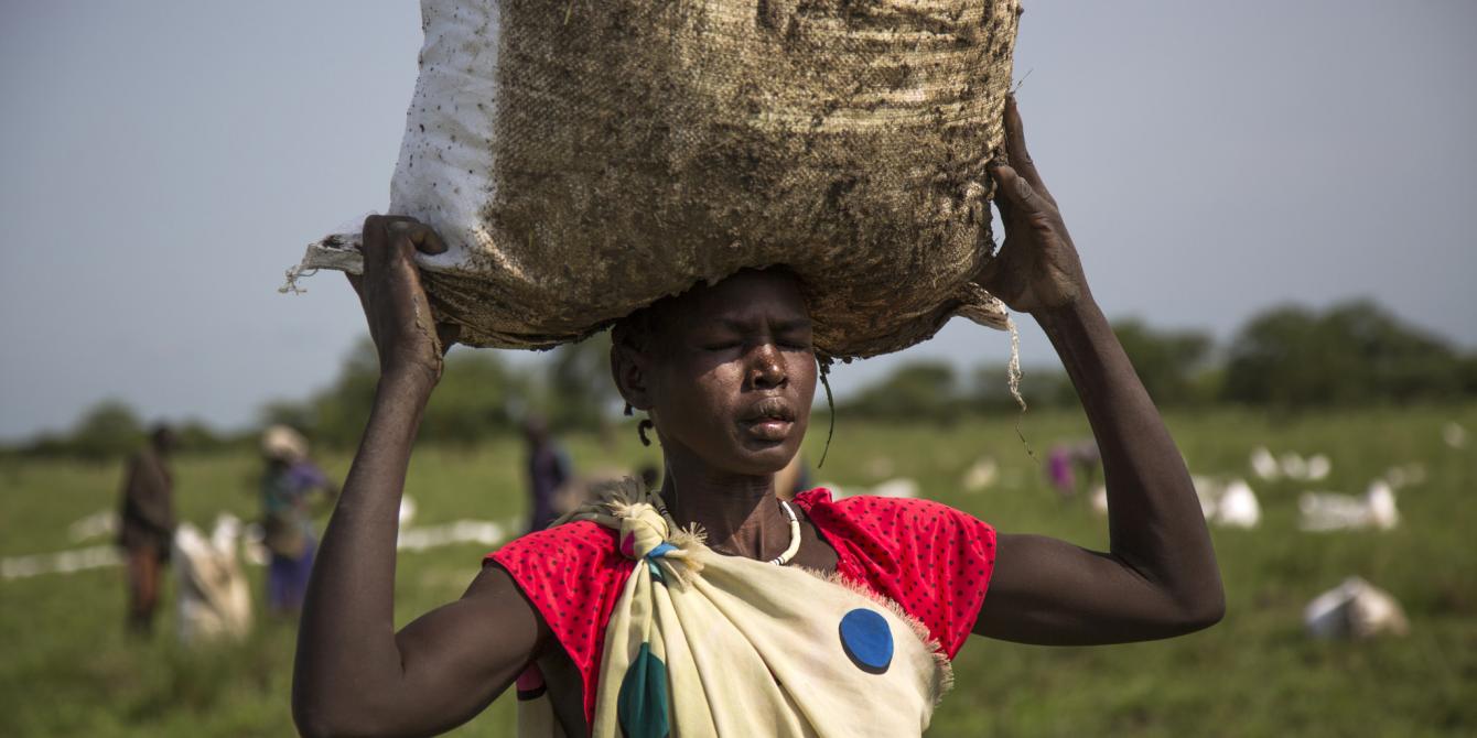A woman carries a sack of food airdropped by the World Food Programme (WFP) and distributed by Oxfam in Padding, Jonglei, South Sudan. Albert González Farran/Oxfam