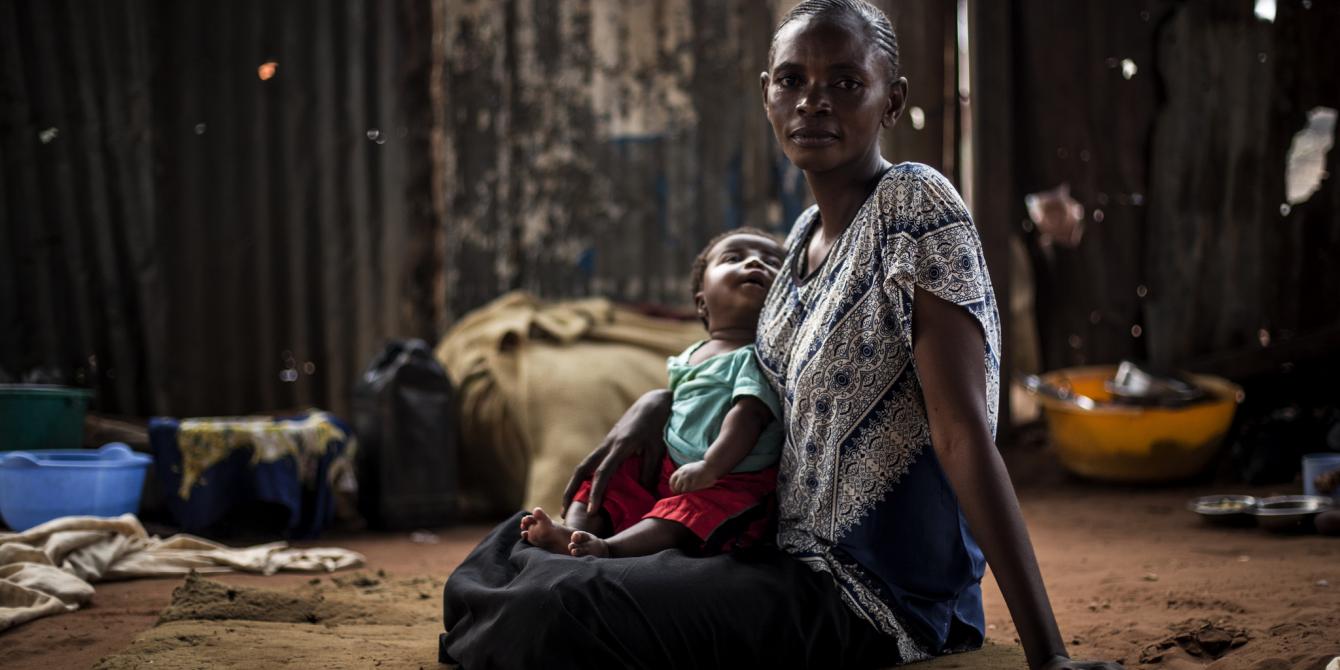 John Wessels / Oxfam Berte sits with her child inside a church in Kasai province, eastern DRC. John Wessels / Oxfam