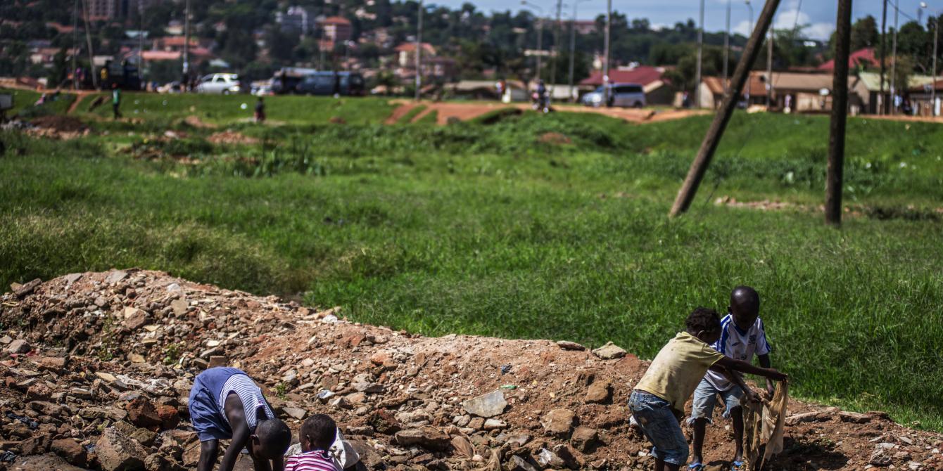Children play by a dirty stream in one of the low-income settlements in Kampala,Uganda.