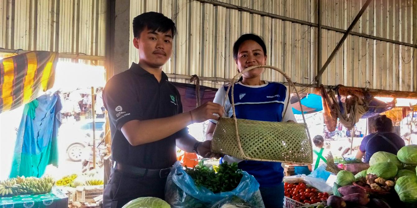 Cutting Plastic Pollution in lao wet markets A student from the National University of Laos hand a bamboo basket to a wet market vendor