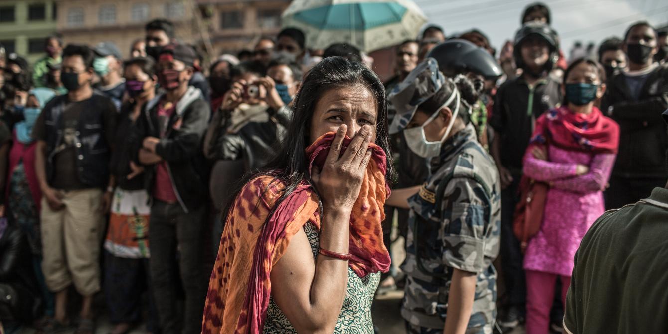 A woman breaks down when a crowd gathers to watch a digger remove rubble from a collapsed building in Gongabu, Kathmandu - Credit: Pablo Tosco/Oxfam A woman breaks down when a crowd gathers to watch a digger remove rubble from a collapsed building in Gongabu, Kathmandu - Credit: Pablo Tosco/Oxfam
