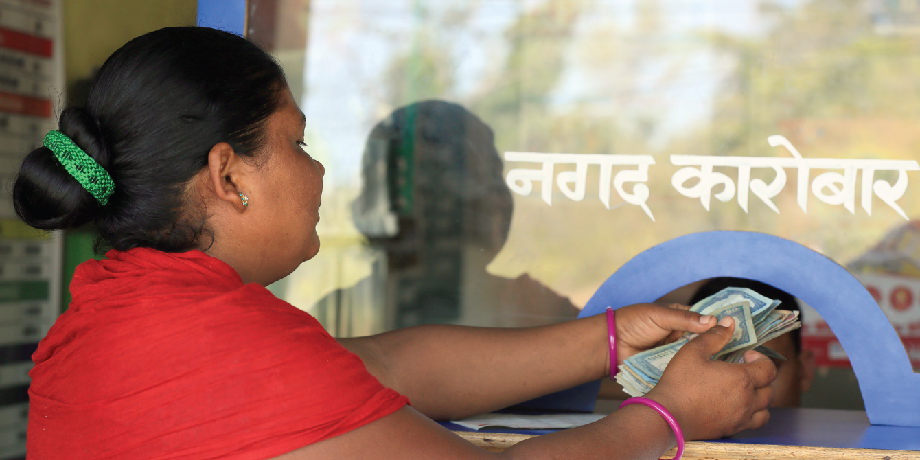 A woman takes out the money send by her husband from India - Credit: Oxfam/OIM/UNDP A woman takes out the money send by her husband from India - Credit: Oxfam/OIM/UNDP