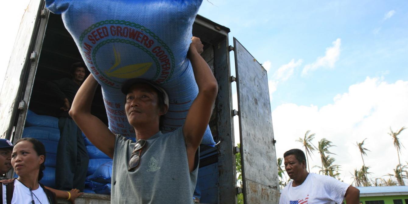 Alex and Romy from the local Tanod or village peacekeepers, assisting the offloading of seeds for distribution to farmers. (Photo: Jane Beesley/Oxfam) Alex and Romy from the local Tanod or village peacekeepers, assisting the offloading of seeds for distribution to farmers. (Photo: Jane Beesley/Oxfam)