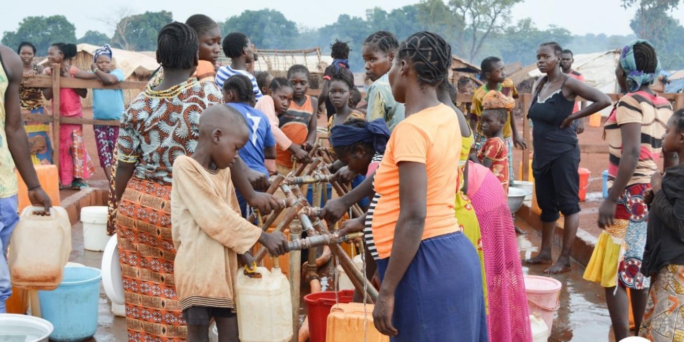 18 juillet 2019 - Des familles viennent remplir leurs bidons à un point d'eau. Le réseau gravitaire installé par Oxfam permet de fournir de l'eau aux 50 000 déplacés du site PK3 de Bria, dans le centre de la RCA. © Aurélie Godet/Oxfam 18 juillet 2019 - Des familles viennent remplir leurs bidons à un point d'eau. Le réseau gravitaire installé par Oxfam permet de fournir de l'eau aux 50 000 déplacés du site PK3 de Bria, dans le centre de la RCA. © Aurélie Godet/Oxfam