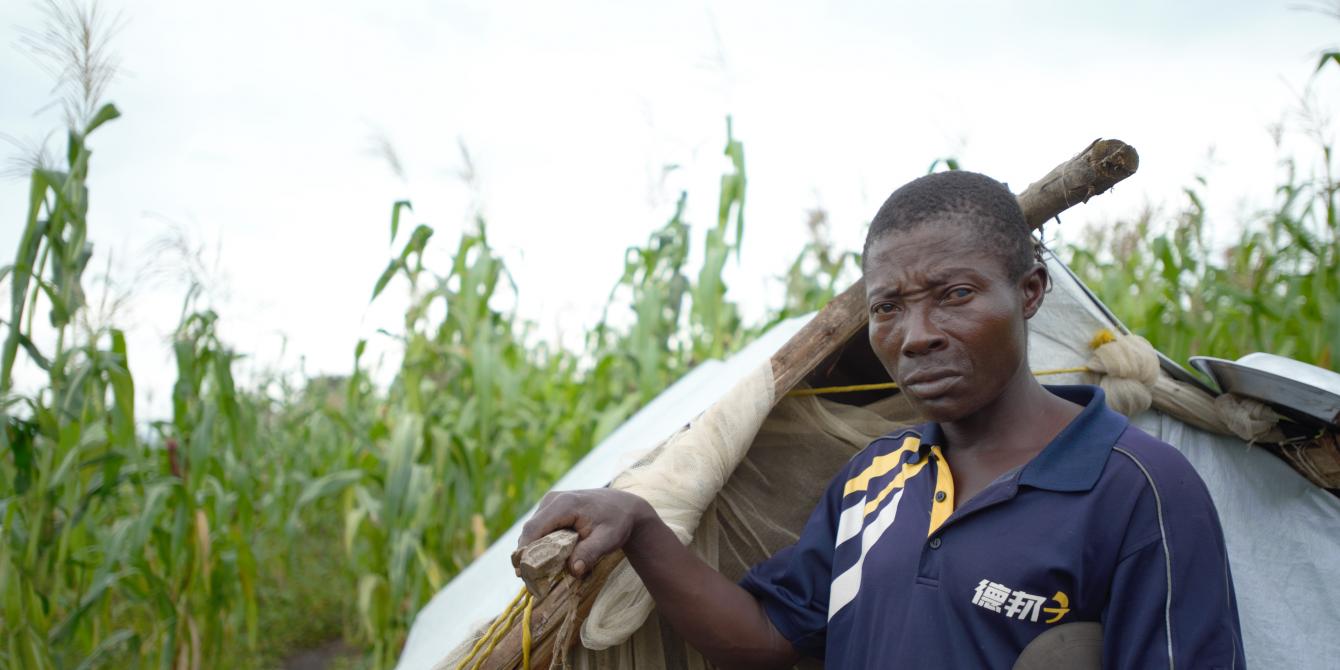 40 year old Kambese infront of his tent in KyakaII Refugee settlement. Photo credit: Julius Kasuja/Oxfam
