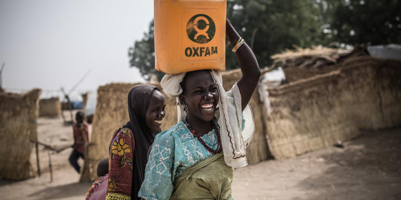 Two women carry water in Oxfam jerry cans at Muna Garage, an IDP camp in Nigeria. Credit: Pablo Tosco / Oxfam Two women carry water in Oxfam jerry cans at Muna Garage, an IDP camp in Nigeria. Credit: Pablo Tosco / Oxfam